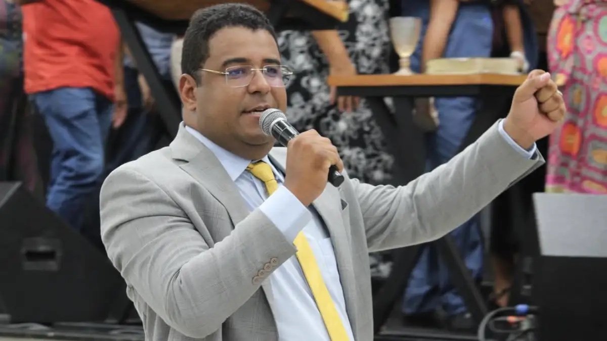 Pr. Jonatas Lins ministrando com microfone em um evento
